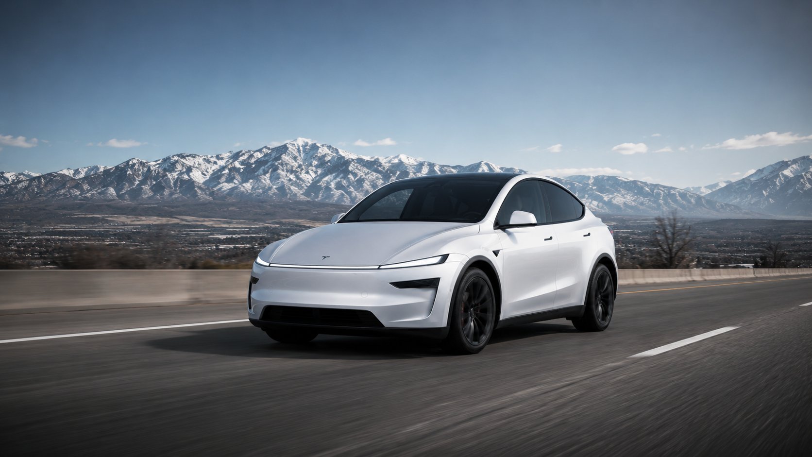 White Tesla on a Utah highway with snow-capped mountains
