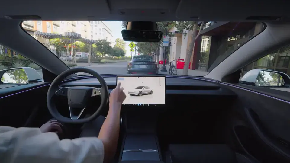 Inside a Tesla Model 3 with the driver-assistance visualization on the touchscreen